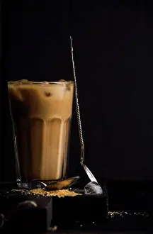 Beverage Prints: Iced coffee with milk in a tall glass, black background, selective focus