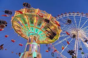 Luminous Prints: Illuminated carousel and Ferris wheel at night in a lively amusement park