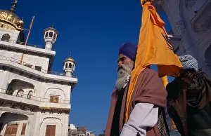 Asian Prints: India, Punjab, Amritsar, Golden Temple With A Pilgrim Flag Bearer Carrying The Sikh Orange Flag Or Nishan Sahib
