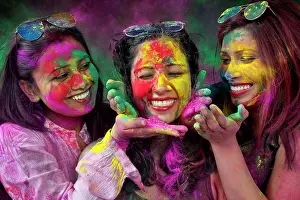 Holi Prints: Three Indian girls playing holi in a holi color festival