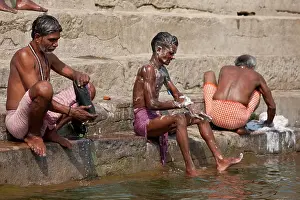 Small Group Prints: Indian men washing themselves and their clothes in waters of The Ganges River at Kali Ghat in City of Varanasi