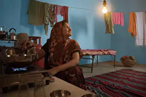 Stove Prints: Indian Woman Cooking Food Looking At Light Bulb, Rural India