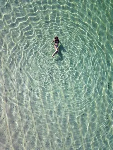 Drift Prints: Indonesia, Bali, Melasti, Aerial view of Karma Kandara beach, woman in water