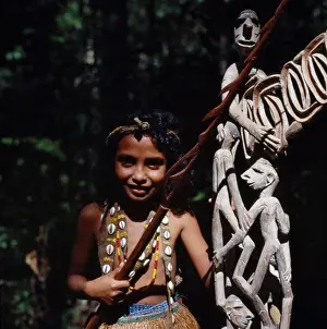 Southeast Prints: Indonesia, Irian Jaya, Sorong, Young Girl Beside Wooden Carvings