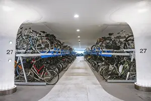 Cycling Prints: Indoor bicycle parking area with stacked bikes on dual-level racks in a modern setting