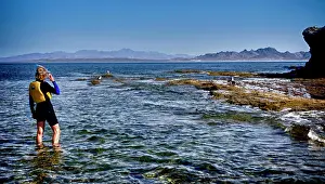 Life Jacket Prints: Isla de Espiritu Santo, Baja, Mexico, Woman snorkeler studies the rocks and surf. (MR)