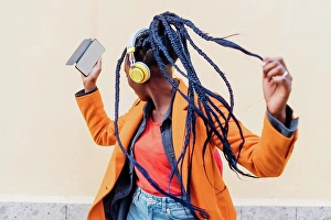 Bame Prints: Italy, Milan, Woman with headphones and smart phone dancing outdoors