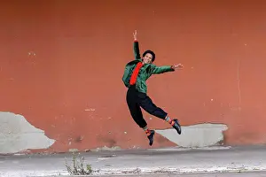 Bame Prints: Italy, Tuscany, Pistoia, Smiling woman jumping against wall