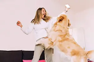 One Young Woman Only Prints: Italy, Young woman playing with dog at home