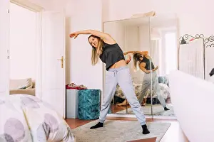 One Young Woman Only Prints: Italy, Young woman stretching at home