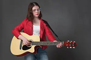 Probe Prints: Junge Frau, die eine klassische akustische Gitarre anschlägt
