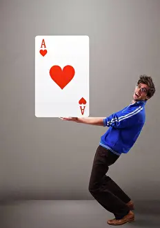 Cards Prints: Junge Mann, der ein rotes Herz hält Attractive young man holding a red heart ace LicenseRF