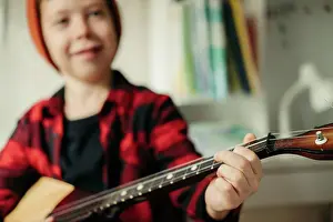 Verrotten Prints: Junge mit rotem Hut und kariertem Hemd spielt auf der Balalaika