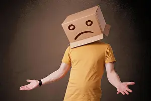 Case Prints: Junger Mann mit einem braunen Karton auf seinem Kopf mit traurigem Gesicht Young man standing with a brown cardboard