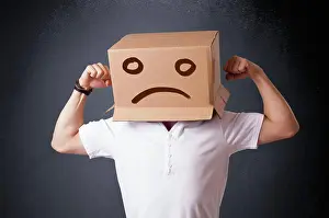 Case Prints: Junger Mann mit einem braunen Karton auf seinem Kopf mit traurigem Gesicht Young man standing with a brown cardboard