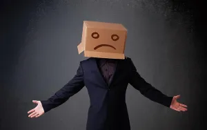 Case Prints: Junger Mann mit einem braunen Karton auf seinem Kopf mit traurigem Gesicht Young man standing with a brown cardboard