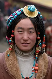Verticals Prints: Khampa woman wears a gold and turquoise hair piece at the Monlam Chenpo