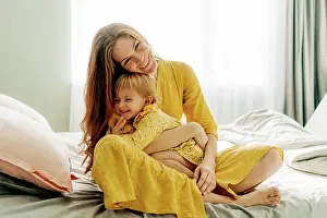 Parenting Prints: Lachende Mutter, die ihre kleine Tochter umarmt