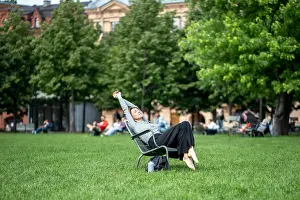 Ausflug Prints: Laid-back lazy and drowsy woman stretching and napping in park lounger during hot summer day Laid-back lazy