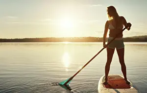 Paddle Prints: Lake, sunset and woman on paddle board for balance