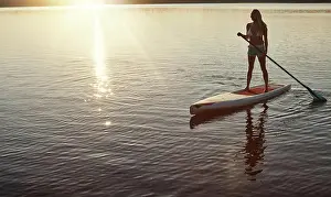 Paddle Prints: Lake, sunset and woman on paddle board for relax