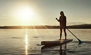 Paddle Prints: Lake, sunset and woman on paddle board for relax