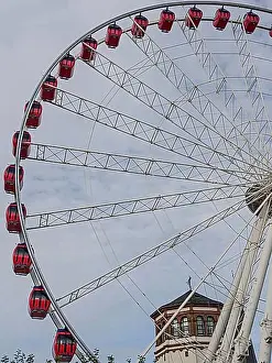 North Rhine Westphalia Prints: Large Ferris wheel with red cabins in front of a cloudy sky