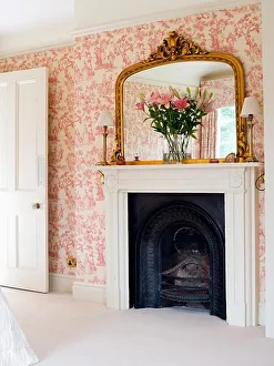 Architecture Prints: Large gilt mirror above fireplace in bedroom with pink Toile-de-Jouy wallpaper