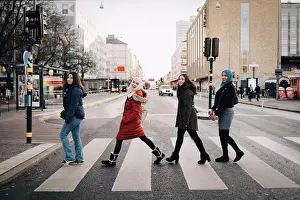 Muslim Prints: Full length of happy female friends crossing street in city