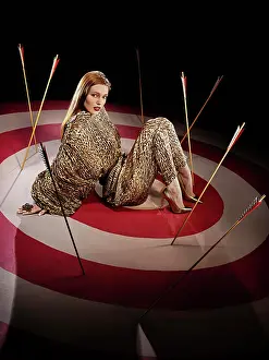 Redhead Prints: Full length portrait of a woman on large hand painted Bulls-eye target with arrows