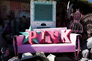 Word Prints: Letters spelling out the word PINK on a vintage iron bench at a curio shop