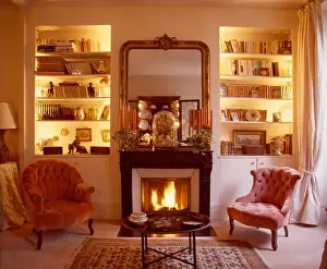 Velvet Prints: Lighted alcove shelves on either side of fireplace with lighted fire in living room with pink velvet chairs