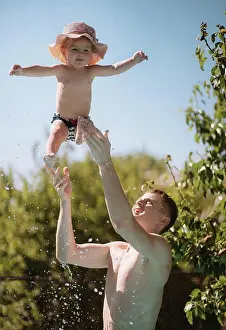 People In Nature Prints: Little girl in a hat swims in the pool with dad