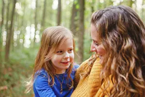 Parenting Prints: A little girl snuggles in her mother's arms as they smile together