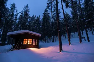 Finland Prints: Log cabin with fire inside, winter, Lemmenjoki National Park, Finland, Europe