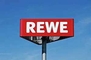 Exterior Photograph Prints: Logo of REWE supermarket chain against blue sky