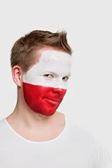 National Flag Prints: London, UK. Portrait of young man with Polish flag painted on face smiling against white background