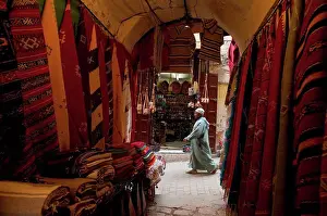 Entryway Prints: Looking past clothes for sale in narrow passageway to man walking down alley; Fez, Morocco