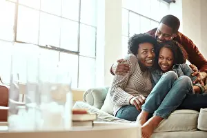 Parenting Prints: Love, bond and family hugging while relaxing together in the living room of their modern house