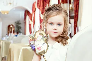 Chic Prints: Lovely blue-eyed girl posing with carnival mask, close-up
