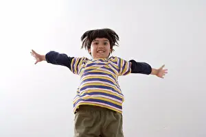 Outstretched Prints: Low angle view of a boy jumping and smiling