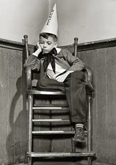 Sulking Prints: Low angle view of a boy wearing a dunce cap