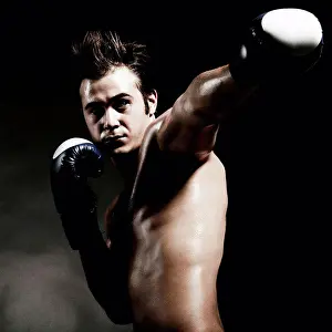 Biceps Prints: Low angle view of Caucasian boxer punching