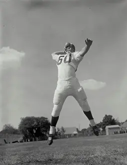 Mid Air Prints: Low angle view of a football player throwing a football