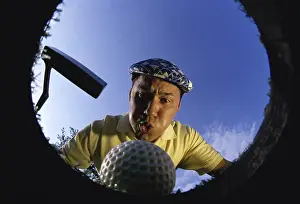 Balance Prints: Low angle view of a golf ball falling into a cup