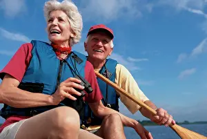 Life Jacket Prints: Low angle view of a senior couple in a row boat