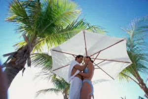 Adore Prints: Low angle view of a young couple embracing on the beach