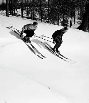 Sweater Prints: Low angle view of a young couple skiing downhill