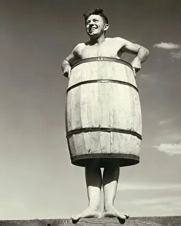 Poverty Prints: Low angle view of a young man wearing a barrel