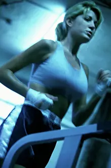 Sseditor Aa Prints: Low angle view of a young woman running on a treadmill